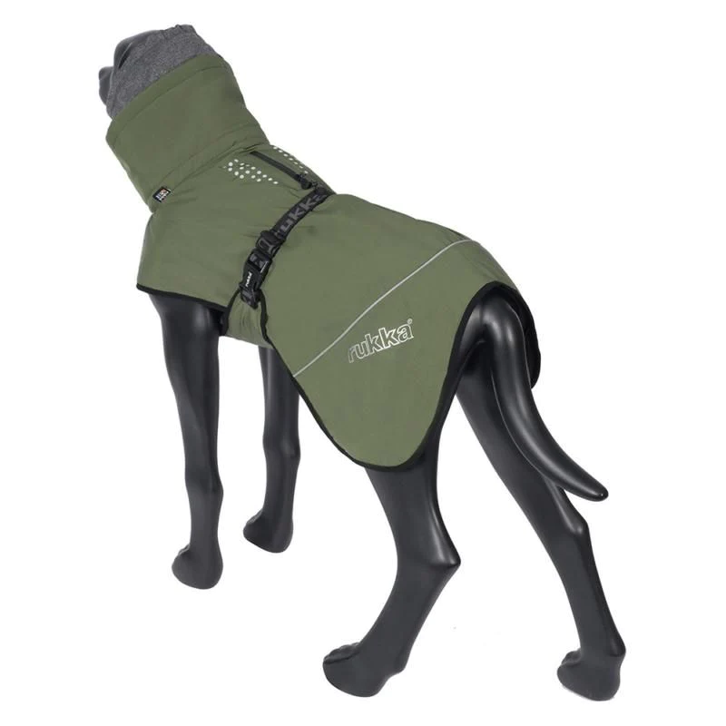 Hund steht im Profil und trägt den Rukka Pets Hundewintermantel Warmup in Oliv, wärmender Mantel mit weichem Innenfutter.